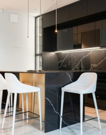 Interior of contemporary kitchen with Balck Marble at island counter in kitchen with black cabinets in modern apartment